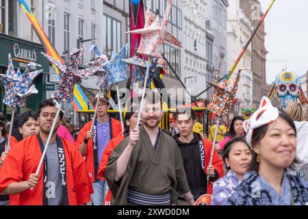 Mitglieder der Japan Society of Northern Ireland nehmen an der jährlichen Belfast Mela multikulturellen Karnevalsparade Teil. Belfast, Großbritannien - 17. August 2024. Stockfoto