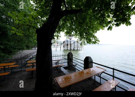 Stegen Am Ammersee, Deutschland. August 2024. Bierbänke und Tische im Regen in einem Biergarten am Ammersee. Im Hintergrund ist ein Bootshaus zu sehen. Quelle: Sven Hoppe/dpa/Alamy Live News Stockfoto