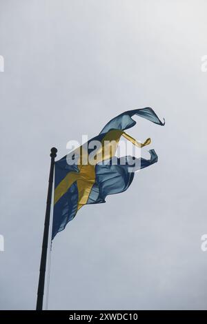 Schwedische gelbe und blaue Nationalflagge weht im Wind vor einem klaren blauen Himmel Stockfoto