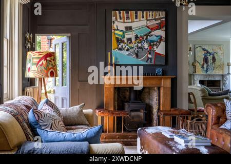 Stehlampe mit moderner Kunst über Holzkamin in Wimbledon Haus, Südwesten von London, England, Großbritannien. Stockfoto