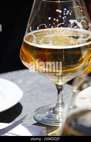 Nahaufnahme eines halb leeren Bierglases auf dem Tisch in einem Restaurant Stockfoto