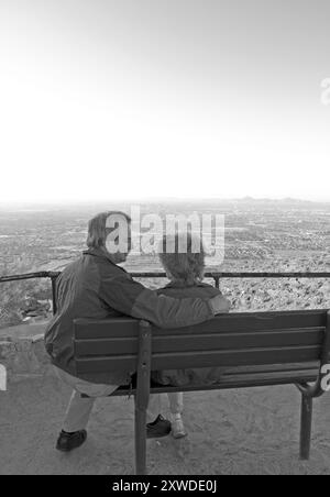 Kaukasisches Paar im Alter von 50 Jahren genießt die Aussicht von einer Bank am Dobbins Lookout, South Mountain Park, Phoenix, Arizona, USA. Stockfoto