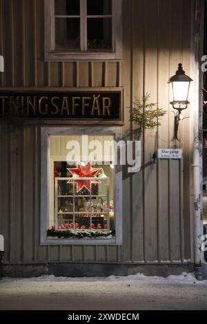 Beleuchtete Fenster im Weihnachtsgeschäft in der malerischen schwedischen Kleinstadt Nora. Stockfoto
