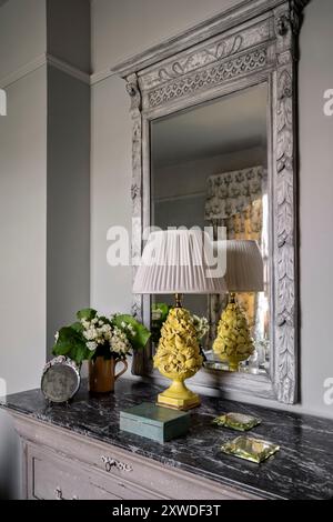 Akkulpturlampen-Sockel mit dekorativem Spiegel und Marmorplatte im Schlafzimmer des Wimbledon-Hauses, Südwest-London, England, Großbritannien. Stockfoto