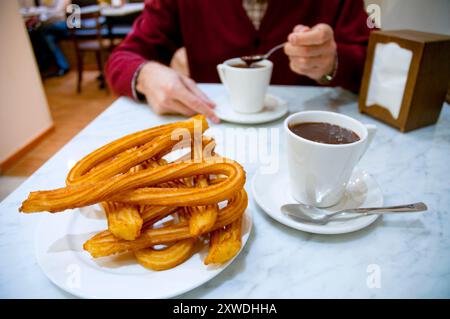 Mann mit Schokolade mit Churros. Schließen Sie die Ansicht. Stockfoto