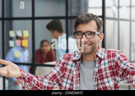 Ein gutaussehender Geschäftsmann in einem karierten Hemd spreizte seine Arme weit Stockfoto