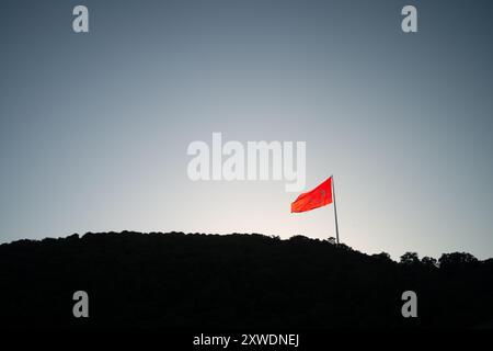 Ein mächtiges Bild der türkischen Flagge, die stolz auf einem Berg winkt und Stärke, Freiheit und Nationalstolz symbolisiert, vor einem Hintergrund von Weite Stockfoto