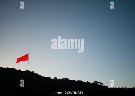 Ein mächtiges Bild der türkischen Flagge, die stolz auf einem Berg winkt und Stärke, Freiheit und Nationalstolz symbolisiert, vor einem Hintergrund von Weite Stockfoto