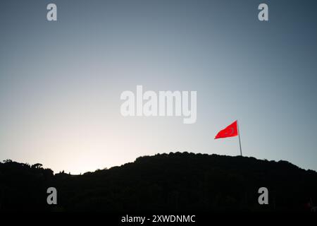 Ein mächtiges Bild der türkischen Flagge, die stolz auf einem Berg winkt und Stärke, Freiheit und Nationalstolz symbolisiert, vor einem Hintergrund von Weite Stockfoto