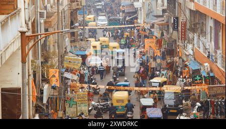 New Delhi, Delhi, Indien - 4. Februar 2024: Verkehr auf der Hauptbasarstraße Straße Paharganj. Autos, Motorräder, Auto Rikscha oder Tuk-Tuk fahren weiter Stockfoto