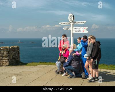 Lands End, Cornwall - Eine Familienposierung für ein unvergessliches Foto vor dem berühmten Lands End-Schild. Stockfoto