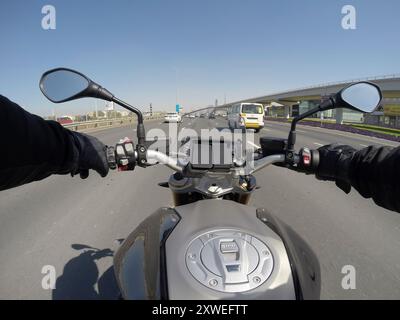 Mann, der ein Motorrad auf der Sheikh Zayed Road in Dubai fährt. Stockfoto