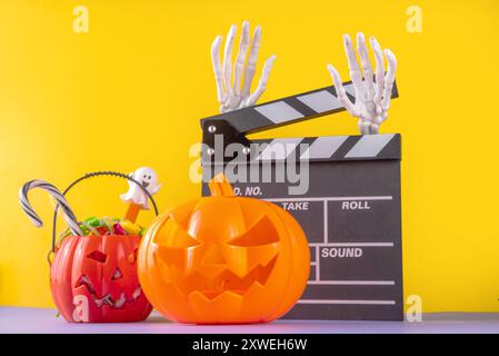 Horrorfilm, Filmabend, Halloween-Kinoparty mit Süßwareneimer, Popcorn, Filmklapperbrett und Halloween-Dekorationen Stockfoto