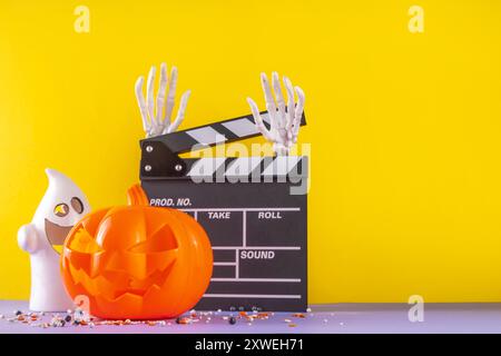 Horrorfilm, Filmabend, Halloween-Kinoparty mit Süßwareneimer, Popcorn, Filmklapperbrett und Halloween-Dekorationen Stockfoto