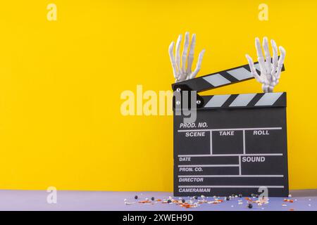 Horrorfilm, Filmabend, Halloween-Kinoparty mit Süßwareneimer, Popcorn, Filmklapperbrett und Halloween-Dekorationen Stockfoto