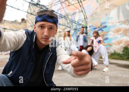 Mann macht Selfie mit einer Gruppe von Menschen im Freien, selektiver Fokus. Hip-Hop-Tänzer Stockfoto