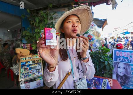 Phnom Penh, Kambodscha. 18. August 2024: Ein kambodschanischer Reiseleiter zeigt einer Gruppe von Touristen in Phnom Penh eine Packung Alain Delon Zigaretten. Der berühmte französische Schauspieler, international bekannt, starb heute. Er hinterlässt ein bedeutendes Erbe an Marken und Unternehmen, das sein Vermögen dank seines internationalen Einflusses machte. Diese beliebte Marke in Asien, die bis 2018 von British American Tobacco vermarktet wurde, war bis 2020 noch auf asiatischen Märkten mit den Slogans „A Taste of France“ & „Signature Taste“ erhältlich. Einige Fremdenführer oder Zigarettenverkäufer haben die Verpackungen als Sammlerstücke aufbewahrt. Quelle: Kevin Izorce/Alamy Live News Stockfoto