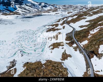 Aus der Vogelperspektive auf die Bergüberquerung Sognefjellsvegen, entlang des gefrorenen Prestesteinsvatnet-Sees, Sognefjell, Norwegen Stockfoto