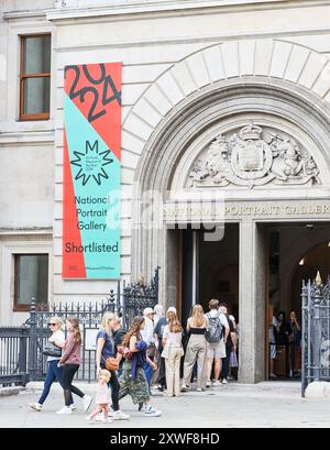 Eine Warteschlange von Touristen, um die National Portrait Gallery, Trafalgar Square, London, England zu betreten. Stockfoto