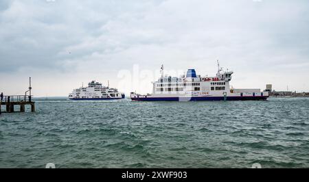 Die Fähren der Isle of Wight passieren einander im Hafen von Portsmouth. Man fischt am Pier. Stockfoto