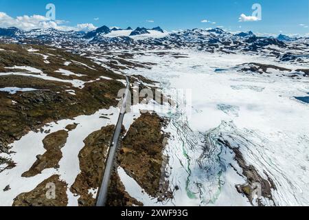 Aus der Vogelperspektive auf die Bergüberquerung Sognefjellsvegen, entlang des gefrorenen Prestesteinsvatnet-Sees, Blick auf Gletscher, Sognefjell, Norwegen Stockfoto