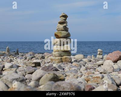 Gestapelte Steine zu Türmen und Figuren am Strand sind beliebte Fotomotive, die Touristen als Zeichen von Balance und Achtsamkeit aufhäufen. Stockfoto