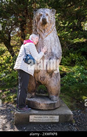 Ein HDR-Bild von einer Dame, die die Schnitzerei von Herkules dem Grizzlybären in Langass-Holz, North Uist, Äußere Hebriden, Schottland, 5. August 2024 Stockfoto