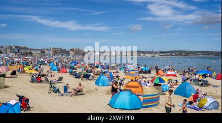 Panorama of a crowded Weymouth beach on a hot  summers day in Weymouth, Dorset, UK on 16 August 2024 Stockfoto