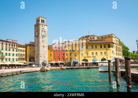 Malerischer Blick auf traditionelle helle Häuser und den Uhrturm ¨Torre Aponale¨ im historischen Zentrum der Stadt Riva del Garda, Italien Stockfoto