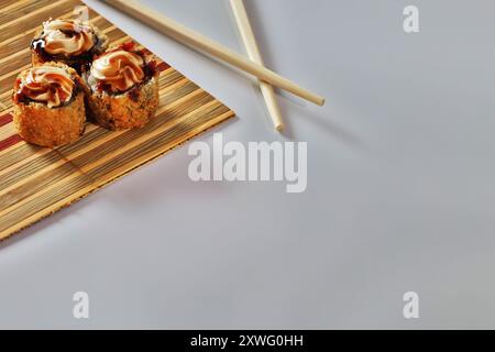 Drei heiße Brötchen mit Frischkäse und Tara-Sauce auf einer kleinen Matte. Stockfoto