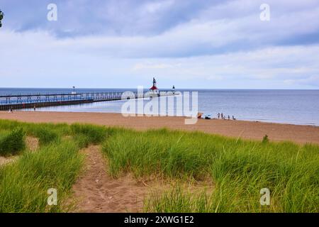 Leuchtturm und Pier am Sandy Beach mit Blick auf Grassy Dunes auf Augenhöhe Stockfoto