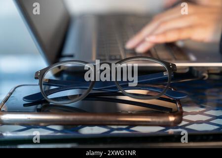 Eine Person tippt auf einem Laptop mit der Hand auf der Tastatur Stockfoto