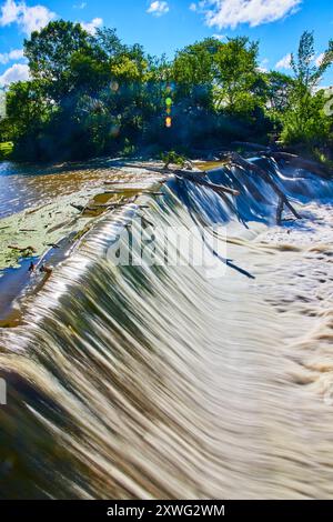 Kleiner Wasserfall über Damm im Wald mit sanfter Wasserbewegung Stockfoto
