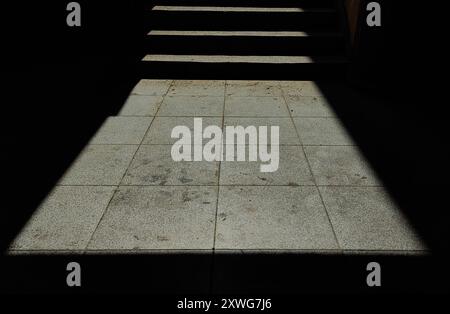 Sonnendurchflutete Treppe und Betonfliesen: Weitwinkelperspektive von Licht und Schatten in einer Alley Street. Stockfoto