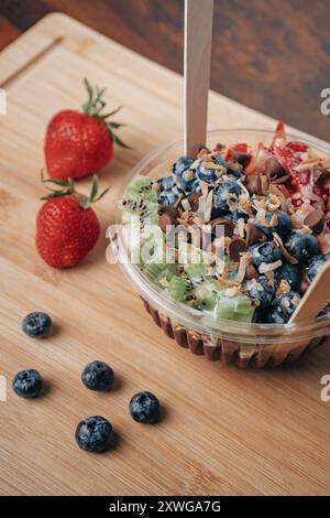 Frische Acai Schüssel mit Erdbeeren, Kiwi, Heidelbeeren und Schokolade Stockfoto