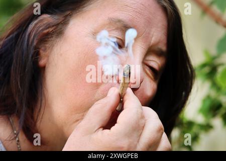 Indischer Hanf, Marihuana, mary jane (Cannabis sativa), Frau, die einen Joint raucht Stockfoto