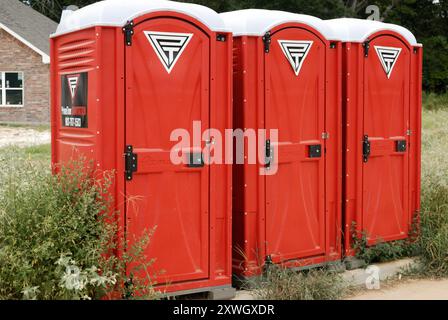 Drei tragbare Toiletten nebeneinander an sonnigen Tagen. Stockfoto