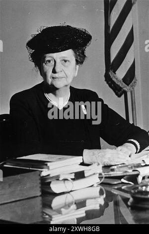 Porträt von Frances Perkins, der an ihrem Schreibtisch sitzt. Sie war Roosevelts Arbeitsministerin. Die erste Ernennung einer Frau in das US-Kabinett. Ihre Ernennung wurde von Wirtschafts-, Politik- und Arbeiterführern heftig kritisiert. Als Arbeitsministerin setzte sie sich für die Verabschiedung des Sozialversicherungsgesetzes ein, befürwortete höhere Löhne und trug zur Standardisierung der staatlichen Industrierechtsvorschriften bei. Stockfoto