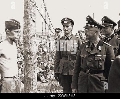 Heinrich Himmler beobachtet einen jungen sowjetischen Gefangenen während eines offiziellen Besuchs in einem Kriegsgefangenenlager in der Nähe von Minsk. Auf dieser Reise wurde er Zeuge eines Massakers an Juden durch ein Einsatzkommando, das die Aufgabe hatte, alle Juden zu vernichten. Stockfoto