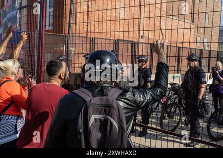 Chiago, USA. August 2024. Demonstranten schreien Polizisten in der Gegend zwischen den beiden Umzäunungen während eines Protestes in einem Park in der Nähe des United Center, wo die Demokratische Nationalkonvention stattfindet, in Chicago, IL am Montag, den 19. August 2024 an. Mindestens vier Personen wurden verhaftet, nachdem die Demonstranten einen der Umzäunungen durchbrochen hatten, die das Ereignis vor Demonstranten schützen sollten. Quelle: SIPA USA/Alamy Live News Stockfoto