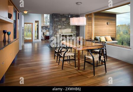 Moderner Speisesaal mit großem Panoramafenster und Steinkamin Stockfoto