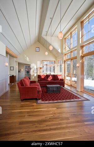 Wohnzimmer mit moderner Hütte mit Kathedraldecke und Fensterwand Stockfoto