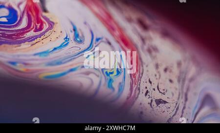 Ölflecken. Unschärfe Tintenmischung. Defokussierte lila rosa blaue gelbe Farbe Acrylemulsion Blasen Welle auf dunklem abstrakten Kunsthintergrund. Stockfoto