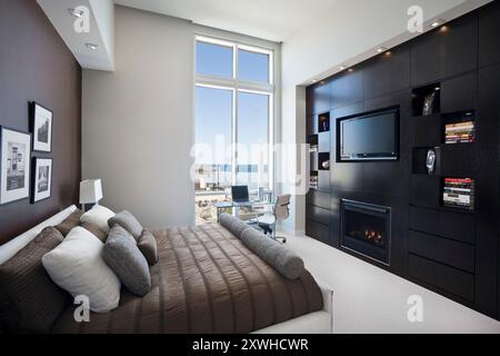 Modernes Schlafzimmer mit maßgefertigtem Wandschrank und Kamin Stockfoto