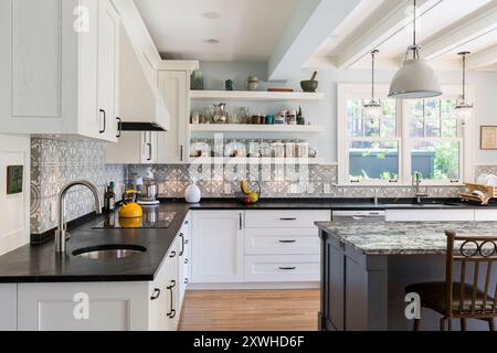 Neue Küche in älterem Haus mit gemusterten Zementfliesen Backsplash und schwarzen Specksteinarbeitsplatten Stockfoto