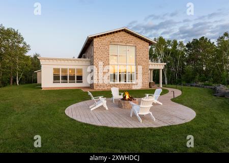 Runde geschwungene Terrasse und Bürgersteig im Hinterhof eines neuen Steinhauses, das im Stil eines alten französischen Bauernhauses erbaut wurde Stockfoto