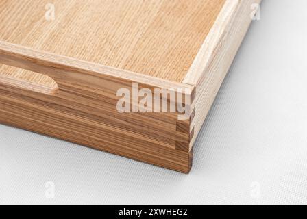 Massive Eschenholzschale mit Schwalbenschwanzfugen und seitlichen Aussparungen für einfaches Tragen in Großansicht auf weißem Hintergrund Stockfoto