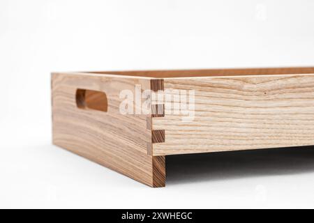 Massive Eschenholzschale mit Schwalbenschwanzfugen und seitlichen Aussparungen für einfaches Tragen in Großansicht auf weißem Hintergrund Stockfoto