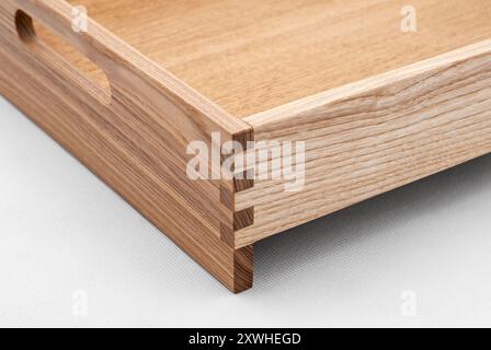 Massive Eschenholzschale mit Schwalbenschwanzfugen und seitlichen Aussparungen für einfaches Tragen in Großansicht auf weißem Hintergrund Stockfoto