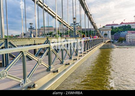 Budapest, Ungarn - 7. Juli 2024: Detaillierter Blick auf die Kettenbrücke mit Fußgängern und malerischer Umgebung, die das berühmte architektonische Featur hervorhebt Stockfoto